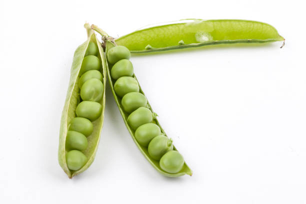 istock fresh pea pods isolated on white background. 1159355800