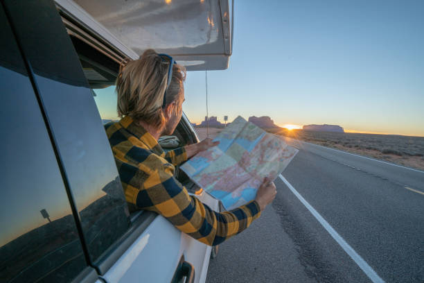 concetto di viaggio su strada; giovane all'interno del camper che guarda la road map per le indicazioni per esplorare i parchi nazionali e la natura pronti per l'avventura. - navajo national monument foto e immagini stock