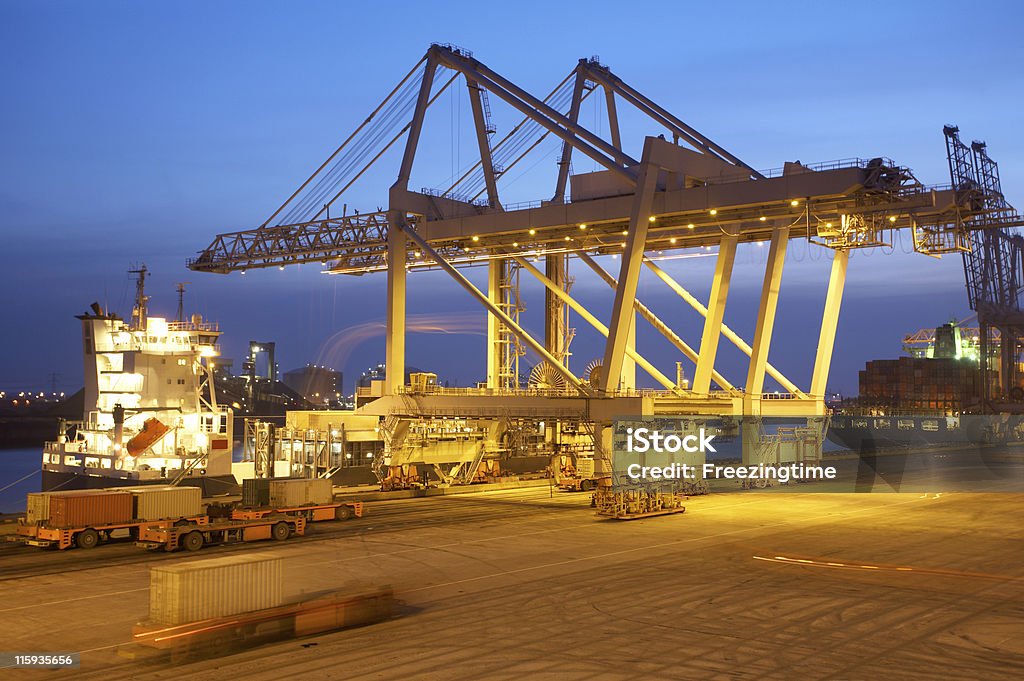Une grue de déchargement navire au crépuscule - Photo de Grue portique libre de droits