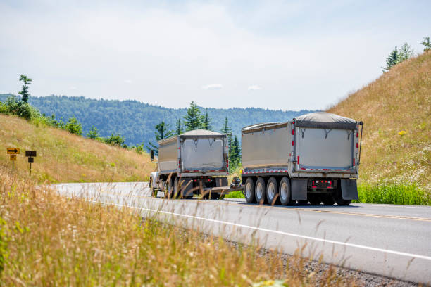 istock Big rig tip truck transporting cargo in covered bulk tip trailers going downhill 1159357483