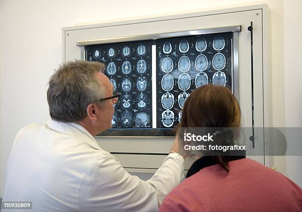 Doctor With Female Assistent Analysing A Mriscan Stock Photo - Download Image Now - Epilepsy, Patient, Doctor