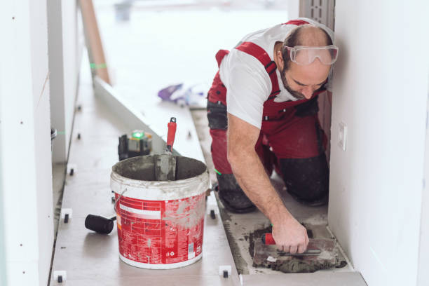 istock Tile mason spreading tile adhesive on the floor 1159359170