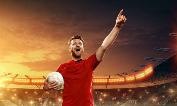 istock Soccer player celebrates victory on a floodlit night stadium 1159360383