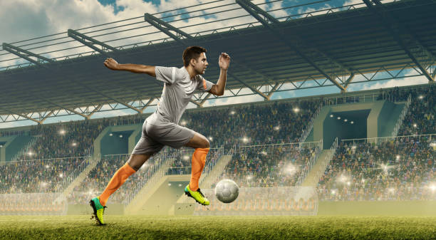 футболист капает мяч на стадионе - kick off soccer player soccer kicking стоковые фото и изображения