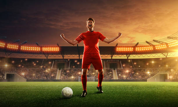 istock Soccer player celebrates victory on a floodlit night stadium 1159360461