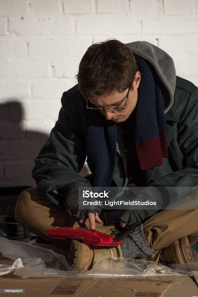 Homeless Man Using Phone Homeless Man In Glasses Using Vintage Phone While Sitting By Brick Wall ...