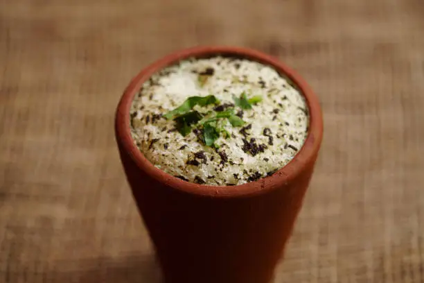 Spiced buttermilk / chaas / moru / sambharam /curd, cool refreshing drink for hot summer in a clay pot and buttermilk chillies