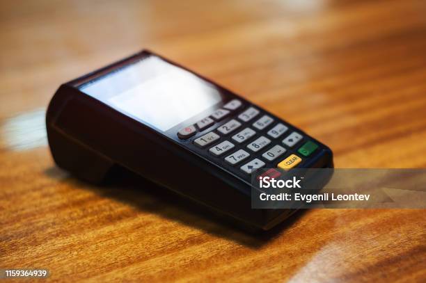 Payment Terminal Lying On A Wooden Table Stock Photo - Download Image Now - Airport Terminal, Paying, Bank - Financial Building