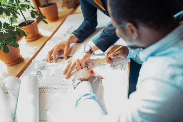 istock Close up of men holding pencils while drawing sketches 1159365575