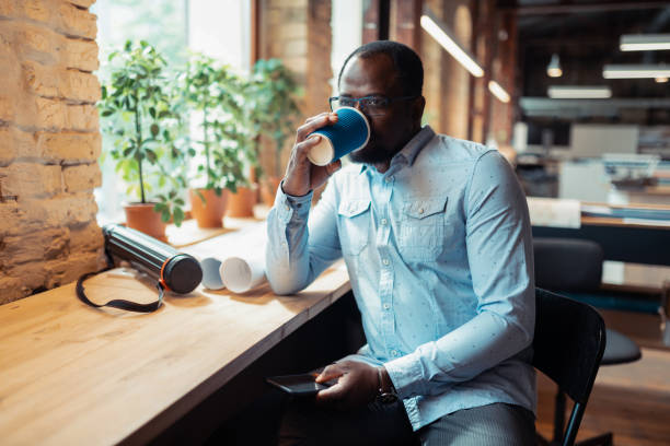 istock Interior designer drinking coffee sitting near window 1159365665