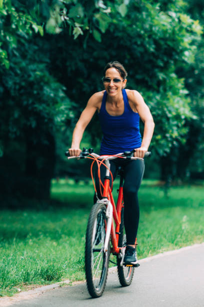 istock Woman Cycling in a Park 1159365801