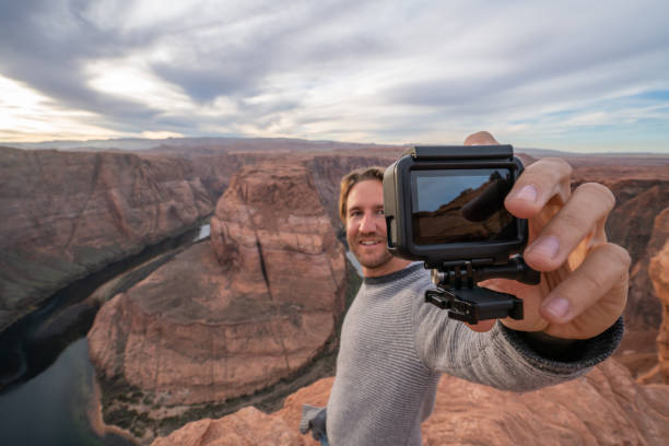 homem novo que toma o selfie com a câmera da ação na curvatura de ferradura no arizona, eua - myspace internet facebook web page - fotografias e filmes do acervo