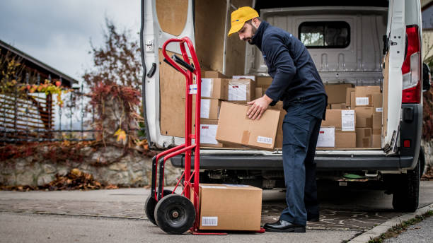 istock Delivery man stacking packages on cart 1159367027