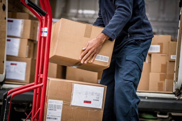 Delivery man stacking packages on cart