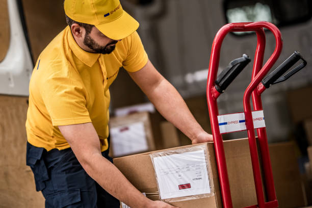 istock Delivery man stacking packages on cart 1159367037