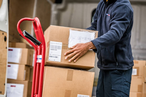 istock Delivery man stacking packages on cart 1159367039