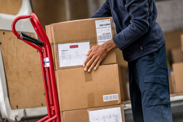 istock Delivery man stacking packages on cart 1159367050