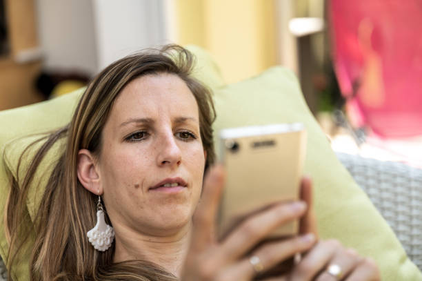 istock Young woman looking at her mobile phone 1159367586