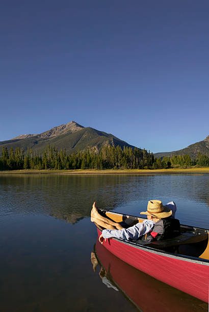 istock Man Relaxing in Canoe with Mountain View 115936821