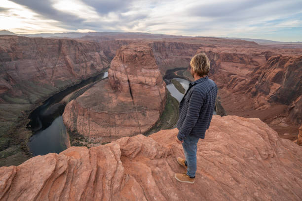 istock Young man contemplating the horseshoe bend in Arizona, USA 1159368564