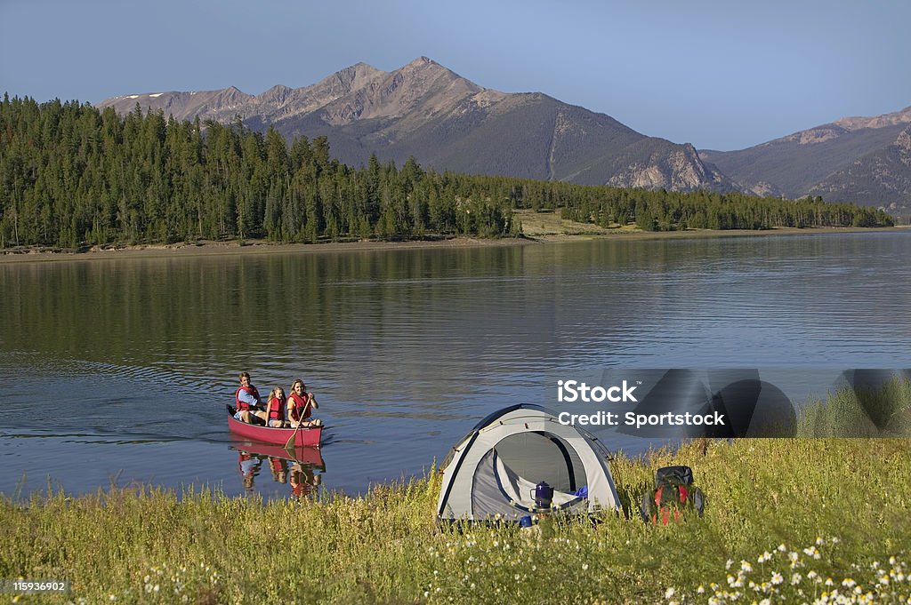 Famiglia in canoa sul lago di montagna da tenda - Foto stock royalty-free di Acqua