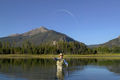 Casting a Fly Fishing Rod in Mountain Lake