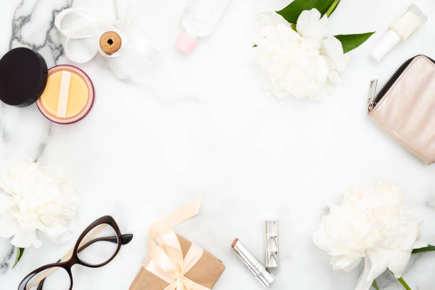 Top view table frame made of women accessoris and cosmetic on marble baclground. Minimal flat lay style blog hero header template, feminine home office desk workspace. Beauty and fashion concept.