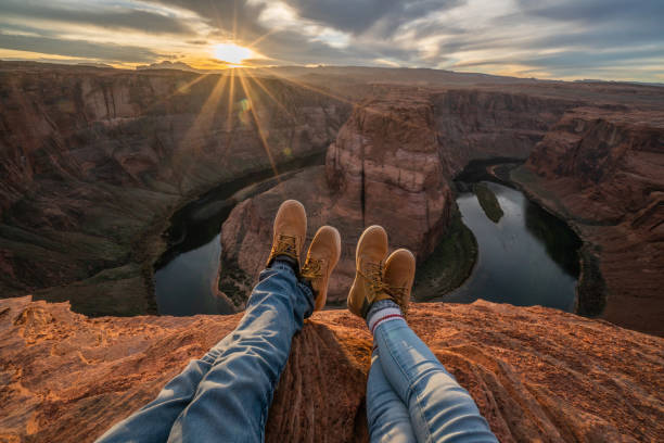 personal perspective of couple relaxing on top of grand canyon; feet view;  people travel vacations relaxation concept - famous destination imagens e fotografias de stock
