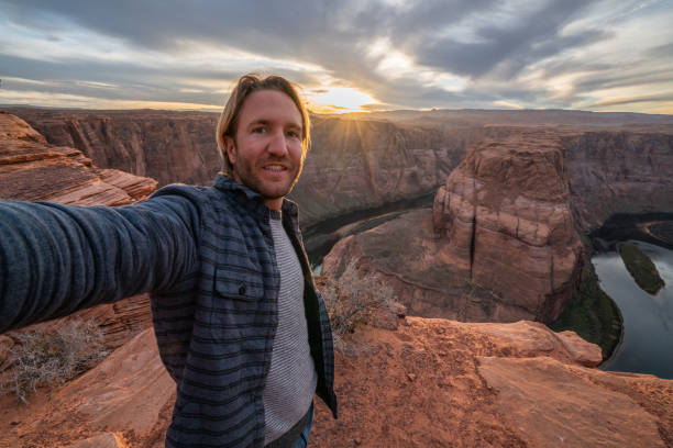 homem novo que toma o selfie na curvatura de ferradura no arizona, eua - myspace internet facebook web page - fotografias e filmes do acervo