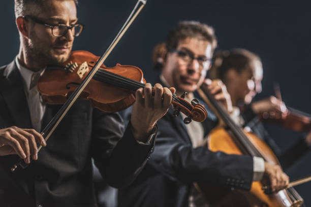 orchestra sinfonica d'archi che si esibisce sul palco - symphonic foto e immagini stock