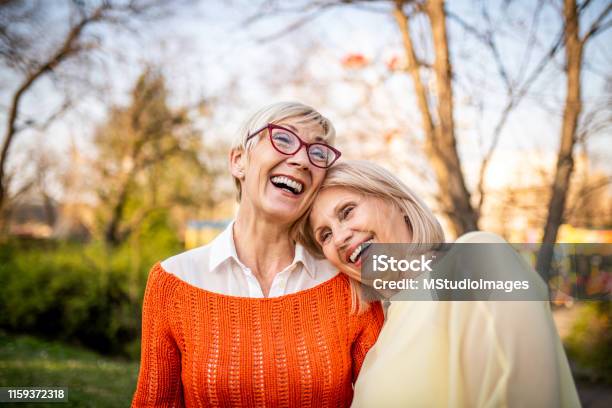 Two Senior Women Laughing At The Park Stock Photo - Download Image Now - Friendship, Senior Adult, Mature Women