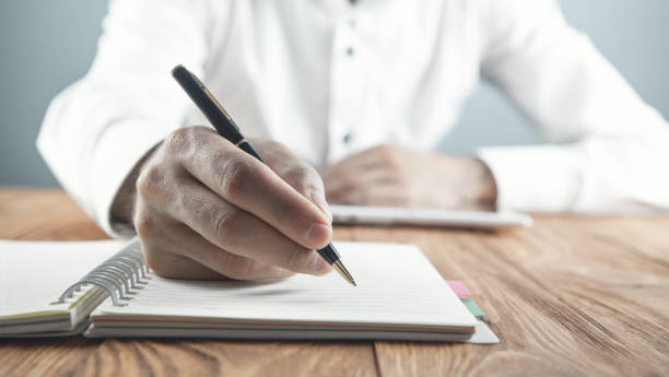 istock Businessman writing on a notepad in business desk. 1159375290