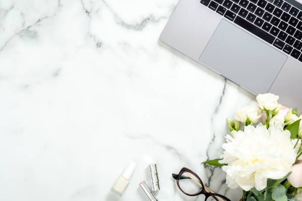 istock Flat lay home office desk. Female workspace with laptop computer, white flowers bouquet, accessories, cosmetic on marble background. Top view feminine background. Business woman workplace concept. 1159376154