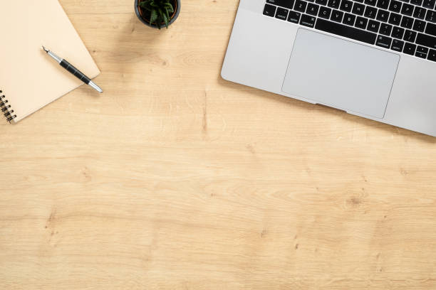 istock Wood office desk table with laptop computer, paper notepad, succulent plant, pen. Minimal flat lay style composition, top view, overhead. Business woman workspace concept. 1159376198