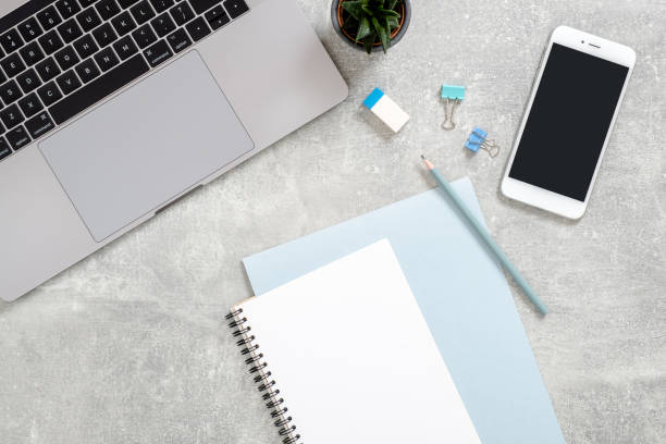 istock Stylish office table desk. Workspace with laptop computer, diary, succulent plant on concrete stone background. Flat lay, top view, Feminine workspace concept. 1159376243