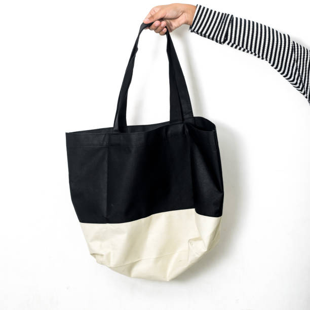 istock Hand holding fabric handbag on white background. 1159376295
