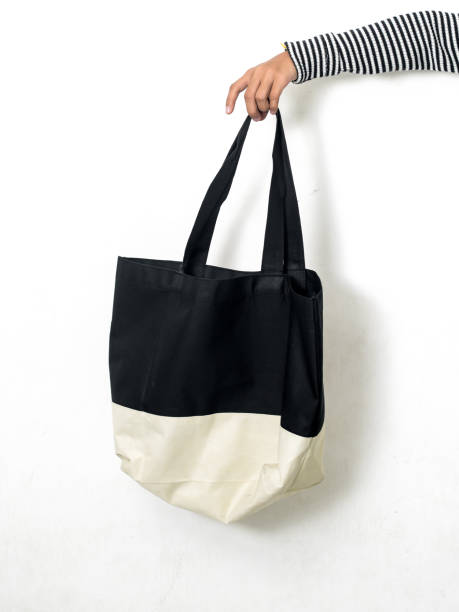 istock Hand holding fabric handbag on white background. 1159376296