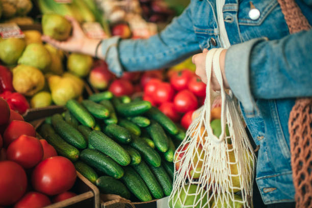 Vegetables and fruit in reusable bag on a farmers market, zero waste concept Close-up of ecologically friendly reusable bag with fruit and vegetables plastic free photos stock pictures, royalty-free photos & images