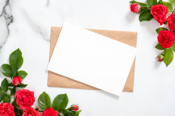 istock Blank postcard with rose flowers frame and craft paper envelope on marble background. Greeting card mockup for Valentine's Day, Mother's or Woman's Day. Flat lay style composition, top view, overhead 1159377047
