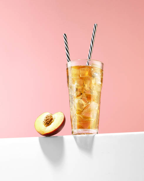 peach ice tea with ice cubes and reusable drinking straws - peach juice imagens e fotografias de stock