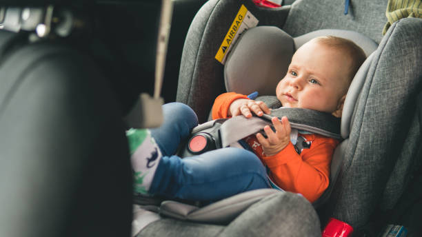 Baby sit in the car seat for safety. stock photo