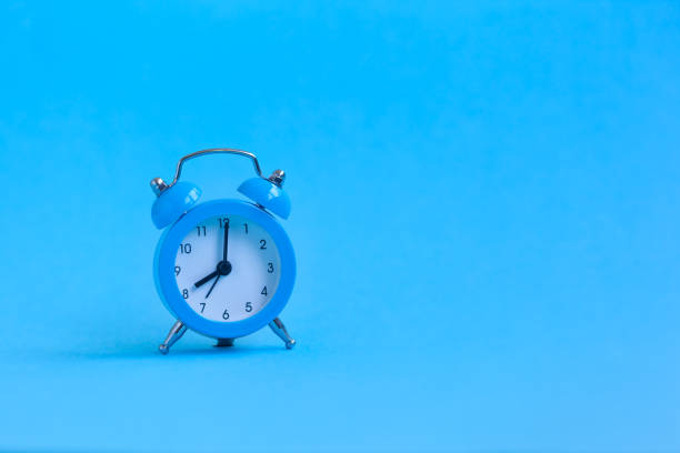 istock Blue alarm clock on blue background. Minimalism. 1159381539