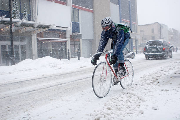 fahrrad courier in montreal in einem schneesturm - overnight delivery stock-fotos und bilder