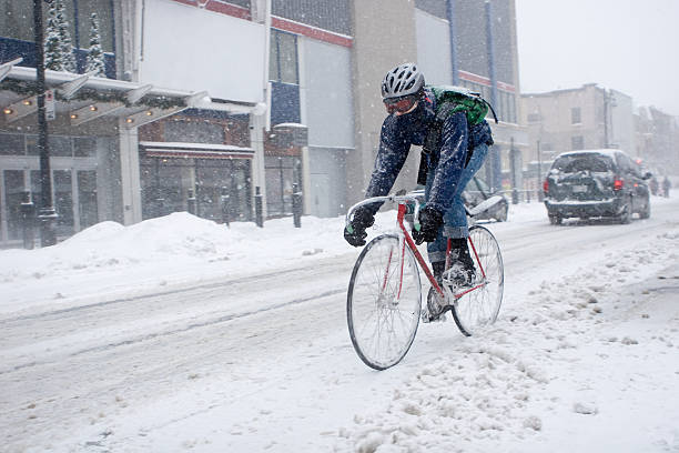 coursier à vélo pendant une tempête de montréal - ice pack photos photos et images de collection