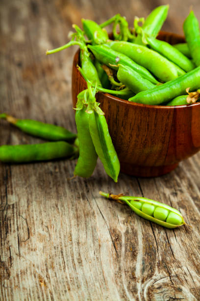 istock Green peas in a wooden bowl. 1159384276