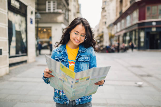 istock Chinese tourist woman holding map 1159385935