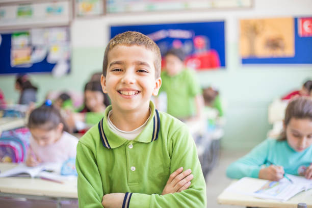 verticale de l'étudiant masculin de dix ans. souriant restant dans la salle de classe - 10 11 years little boys child happiness photos et images de collection