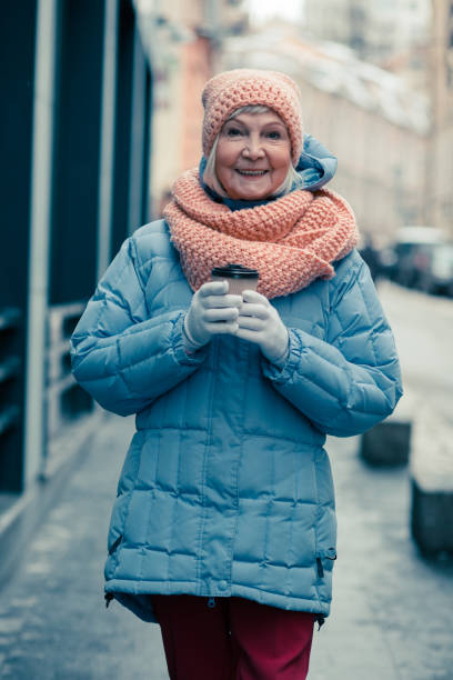 istock Beautiful elderly lady relaxing outdoors with cup of coffee 1159387141