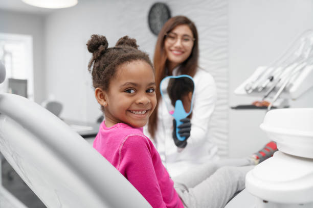 menina que senta-se na cadeira do dentista que olha a câmera e o sorriso - dental implant dental hygiene dentures prosthetic equipment - fotografias e filmes do acervo