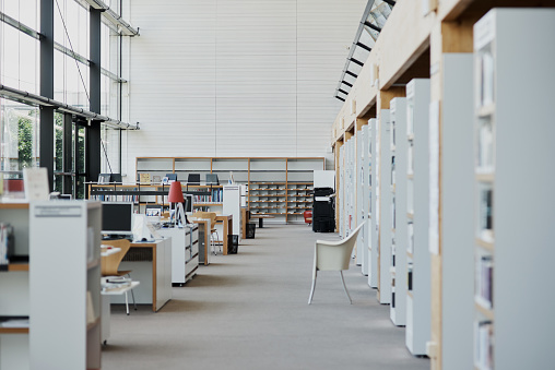 Shot of an empty contemporary library with books stacked on the shelves during the day